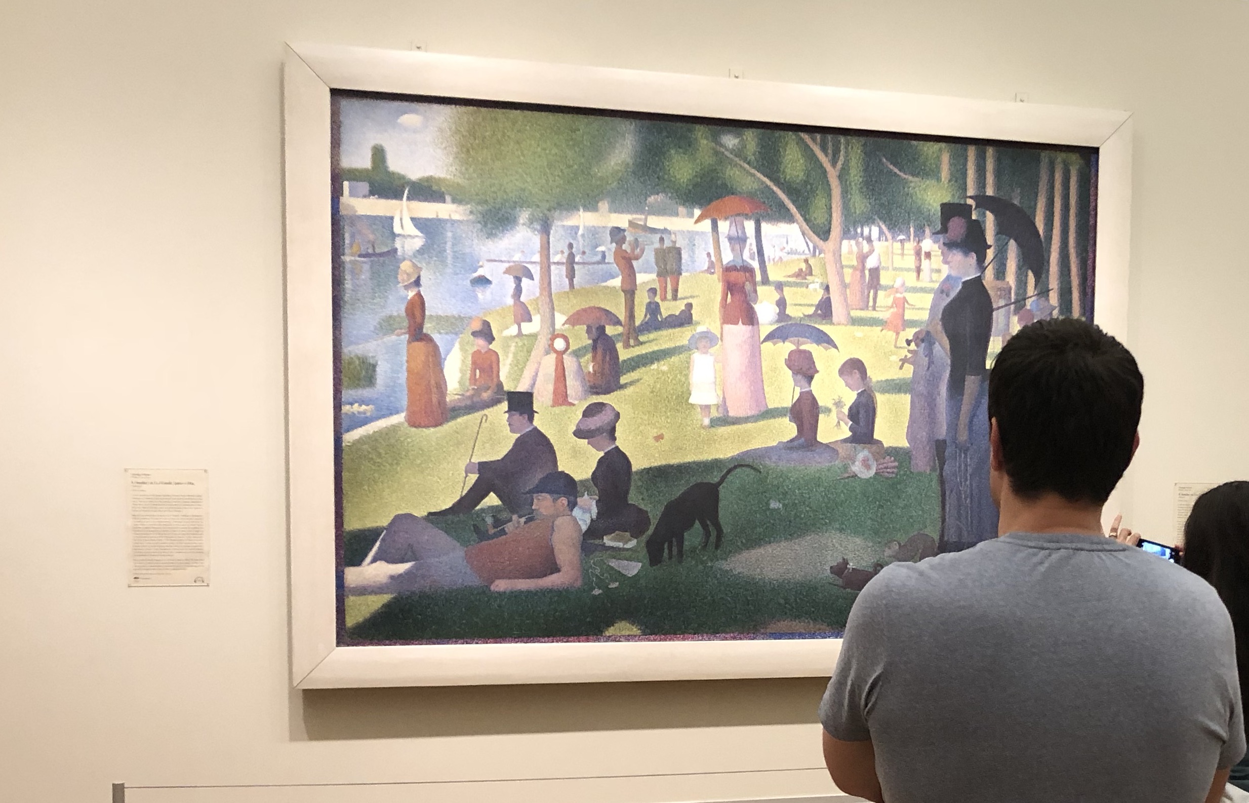 Photograph of Laurence standing in front of a painting called 'A Sunday Afternoon on the Island of La Grande Jatte'. It was made famous by a scene in the movie, Ferris Bueller's Day Off.